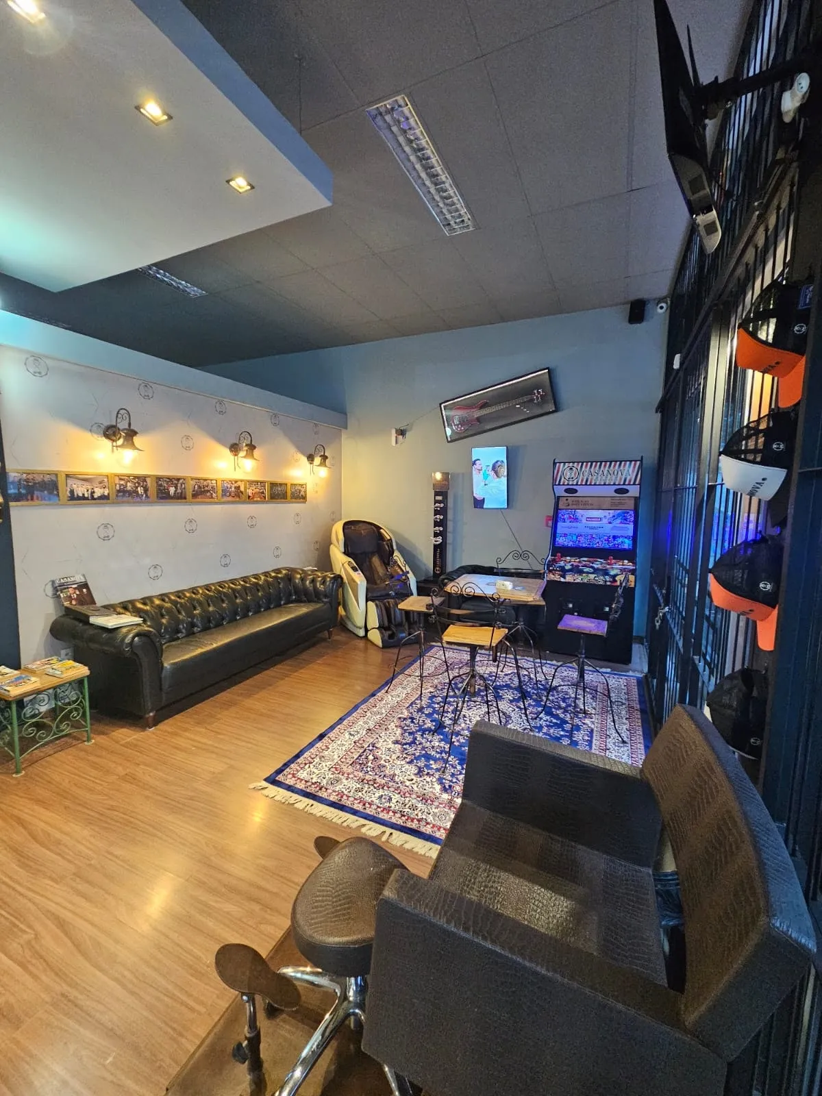 Sala de espera com sofá Chesterfield, poltrona de massagem e fliperama